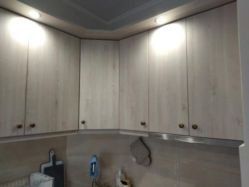 a kitchen with wooden cabinets with lights on it at Studio B3 in Mytilini