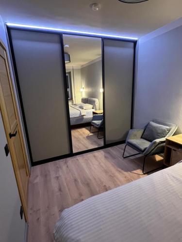 a mirror in a room with a bed and a chair at Mare et Ventus in Ventspils