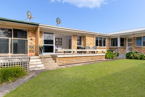 a home with a porch and a lawn at Mount Central Hideaway in Mount Maunganui