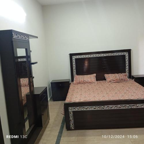 a bedroom with a large bed and a mirror at 5 Marla safari valley bahria Phase 8 in Rawalpindi