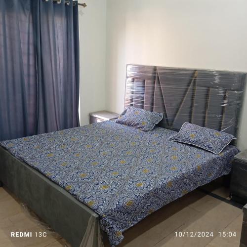 a bed with two pillows on it in a bedroom at 5 Marla safari valley bahria Phase 8 in Rawalpindi