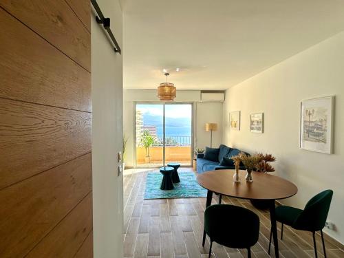 un salon avec une table et un canapé bleu dans l'établissement Mon Cocon entre Mer&Maquis, à Ajaccio