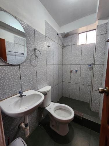 a bathroom with a toilet and a sink and a mirror at Sol de América in La Unión