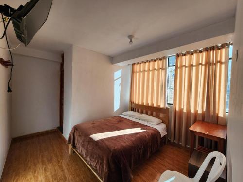 a small bedroom with a bed and a window at Sol de América in La Unión