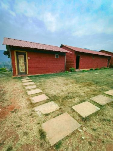 a red building with a stone pathway in front of it at Mysticstays Resort in Wai
