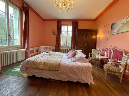 a bedroom with a bed and a chandelier at Gite L'Instant Champenois in Bréviandes