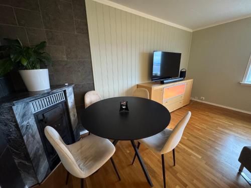 a living room with a table and chairs and a television at Apartment with a beautiful view in the center of Ålesund in Ålesund