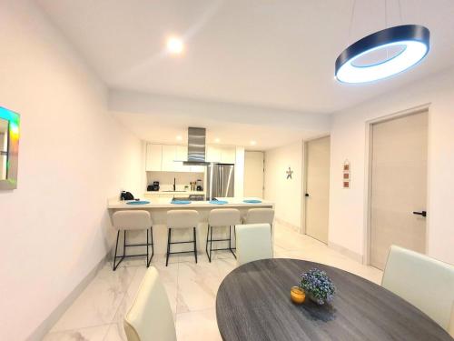 a kitchen with a table and some chairs and a counter at Amaterra 304D Seaside Luxe Condo in Cabo San Lucas
