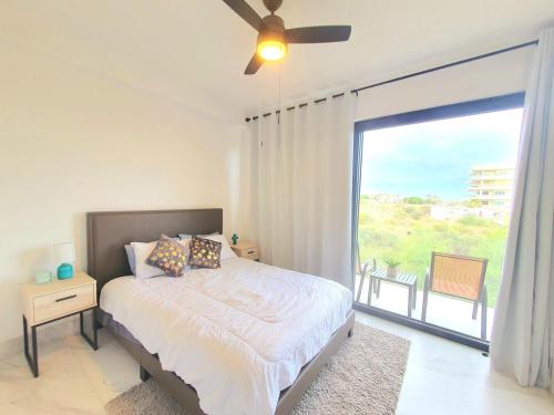 a bedroom with a bed and a large window at Amaterra 304D Seaside Luxe Condo in Cabo San Lucas
