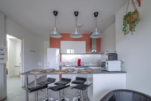 a kitchen with a counter with stools at Tournette -6 pers - Hyper Centre - WIFI in Bourg-en-Bresse