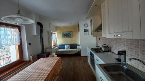 a kitchen with a sink and a couch in a room at Casa Vacanze Tel 121 in Pieve Tesino