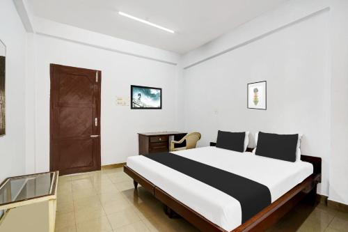 a bedroom with a large bed in a room at Hotel O THE HOME SPOT in Trivandrum