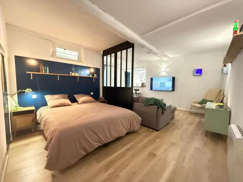 Un dormitorio con una cama grande y un sofá. en Esprit Rétro, en Tourrettes