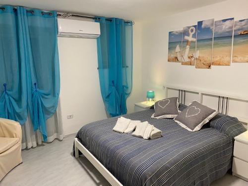 sypialnia z łóżkiem z niebieskimi zasłonami w obiekcie Petra Marina Home w mieście Pisciotta