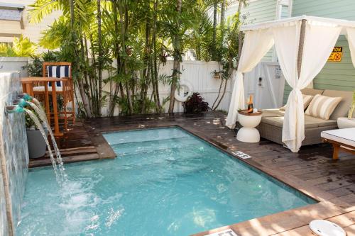 a swimming pool with a waterfall in a backyard at Sombrero Reef Light Suite in Key West