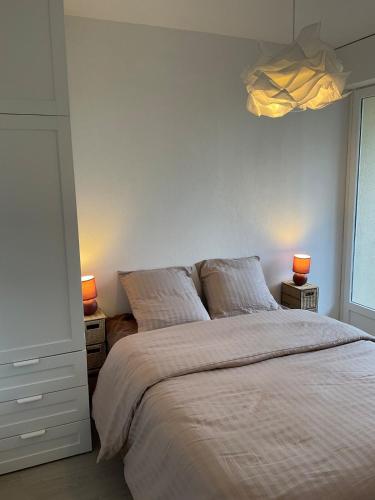 une chambre avec un lit avec deux lampes sur deux tables dans l'établissement Tout à pied, à Cabourg