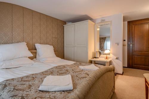 a bedroom with a large bed and a mirror at Къща за гости Карлък in Smolyan