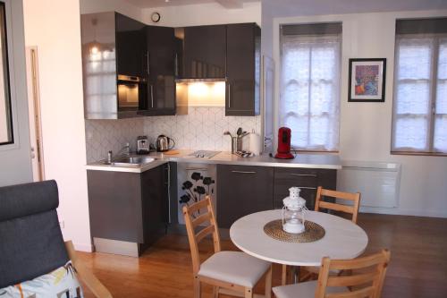 une cuisine avec une table et des chaises dans une pièce dans l'établissement Petit Vitet, à Dieppe