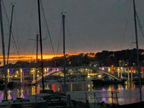 a marina with boats and a bridge at night at Loctycaz Appartement avec jardin in Locmariaquer
