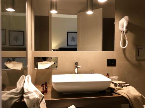 a bathroom with a white sink and a mirror at Vallegrande Nature Resort by Geocharme in Cefalù