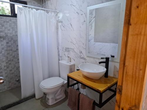 a white bathroom with a toilet and a sink at bosque mar in Ocean Park