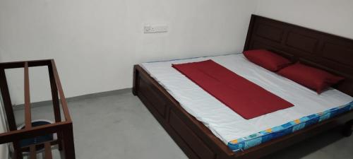 a bedroom with a bed with a red and white blanket at KR Villa in Arugam Bay