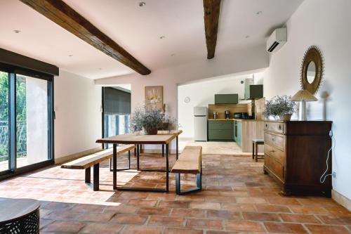 un salon avec une table et une cuisine dans l'établissement Maison Rénovée, Vue sur Nature, à Fontanès