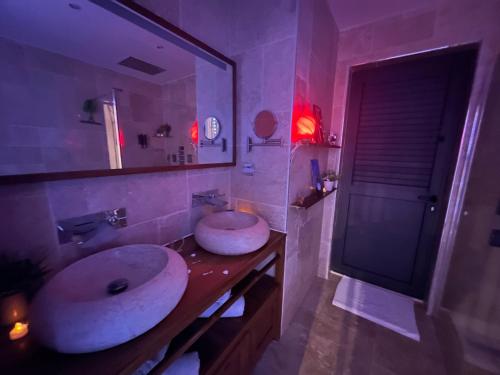 a bathroom with two sinks and a large mirror at L'étoile du Pic in Sainte-Clotilde