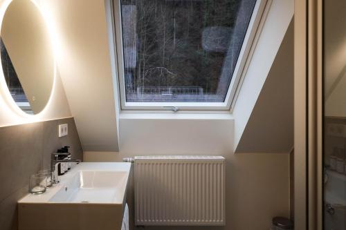 a bathroom with a sink and a window at schlossmühle - lean luxury boutique hotel in Glottertal