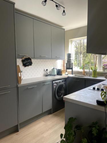 a kitchen with a sink and a washing machine at Bright Pearl in Weston - A Sanctuary in Weston-super-Mare