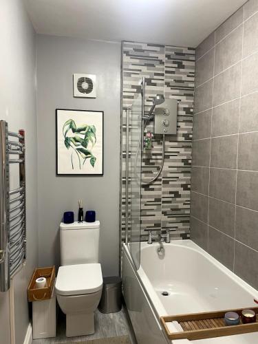 a bathroom with a tub and a toilet and a shower at Bright Pearl in Weston - A Sanctuary in Weston-super-Mare