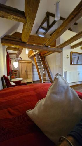 a bedroom with a red bed with a pillow on it at Historisches Apartment in Mühlhausen Thuringia in Mühlhausen
