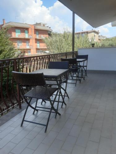 a row of tables and chairs on a balcony at B&B Il viaggio in Borghesiana 