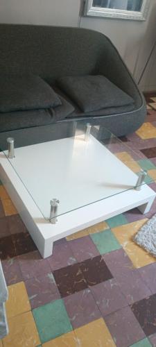 - une table basse blanche devant un canapé dans l'établissement Un nid d amour au coeur de Séte, à Sète