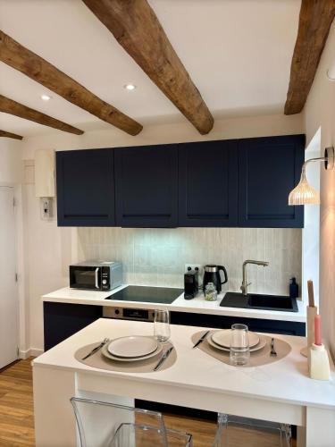 une cuisine avec des armoires noires et un comptoir blanc dans l'établissement Studio 2 Metz Centre-Ville, Gare, à Metz