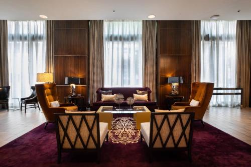 a living room with a couch and a table and chairs at Ambassador Hotel Wichita, Autograph Collection in Wichita