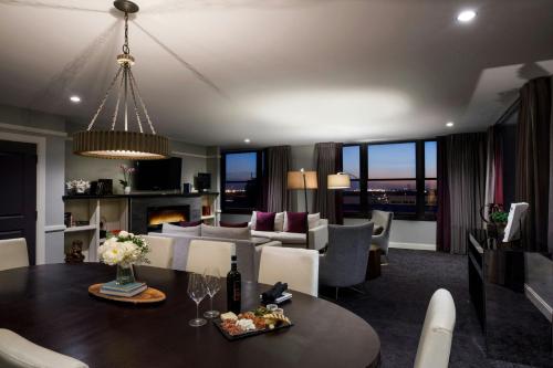 a dining room and living room with a table and chairs at Ambassador Hotel Wichita, Autograph Collection in Wichita