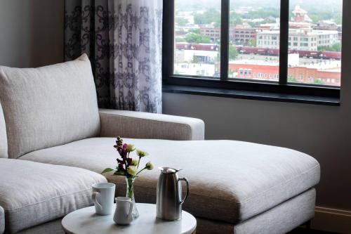 a living room with a couch and a table with flowers at Ambassador Hotel Wichita, Autograph Collection in Wichita