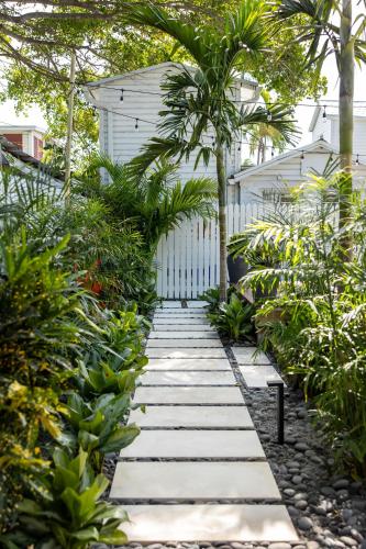 a garden path with plants and a white fence at Key West Light Suite in Key West
