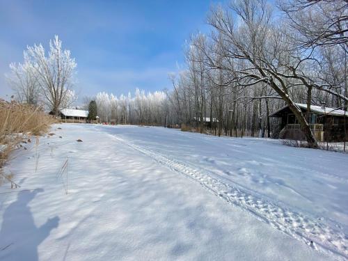 a snow covered road with a barn in the background at Domaine de l Archipel in Sorel
