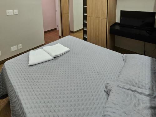 a bed with two white towels on top of it at Lindo AP 2 quartos na Lagoa! in Nova Lima