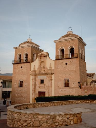 a large brick building with two towers on top at La casa Zamora in Totana