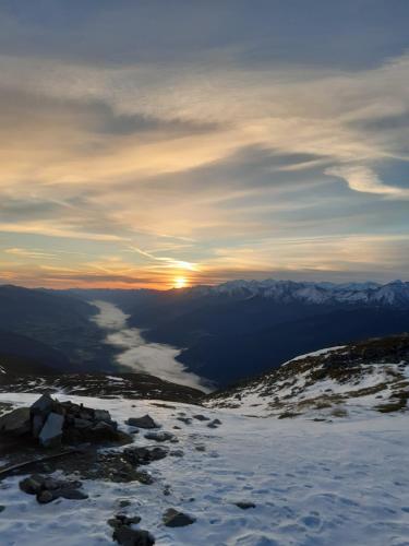a sunset on top of a snow covered mountain at Apartment Graber in Krimml