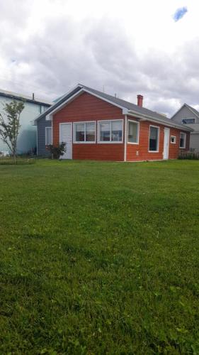 a house with a green lawn in front of it at Cabaña Río Gallegos in Río Gallegos