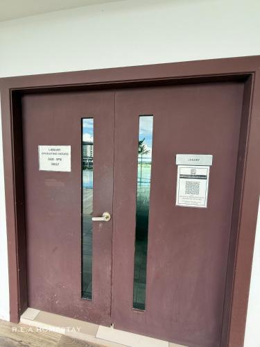 a brown door with two windows in a building at Vivacity Jazz Suites Kuching by REA Homestay in Kuching