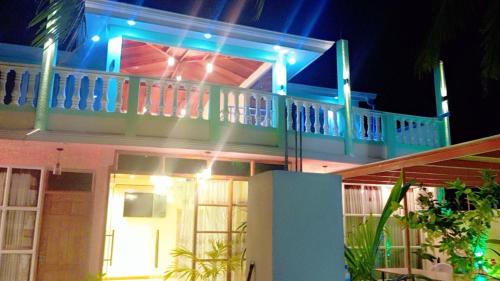 a house with a balcony with blue lights on it at Blue Village in Maamigili