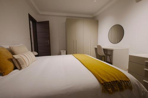 a bedroom with a large bed with a yellow blanket on it at Apartment in Mellieha in Mellieħa