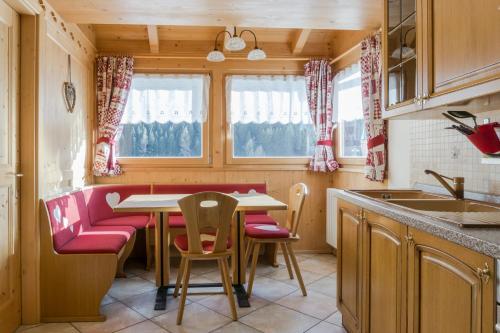 a kitchen with a table and chairs in a kitchen at Dolomites with Love in Mazzin