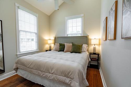 a bedroom with a large bed and two windows at The Lighthouse Penthouse Suite in Key West