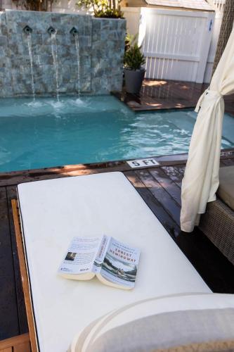 a book sitting on a table next to a swimming pool at The Lighthouse Penthouse Suite in Key West